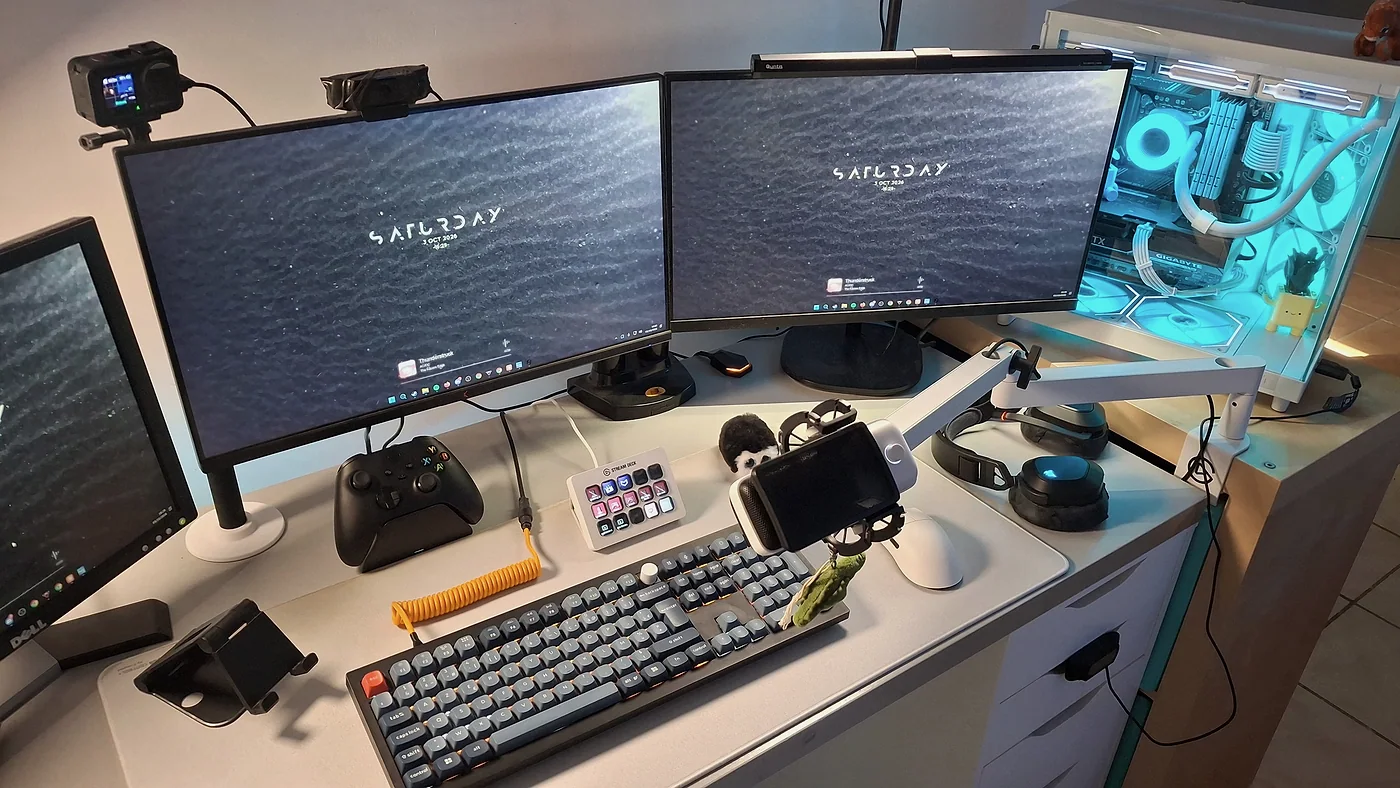 Le bureau vu en légère plongée : clavier, Stream Deck, manette Xbox, casque, souris et bras articulé blanc.